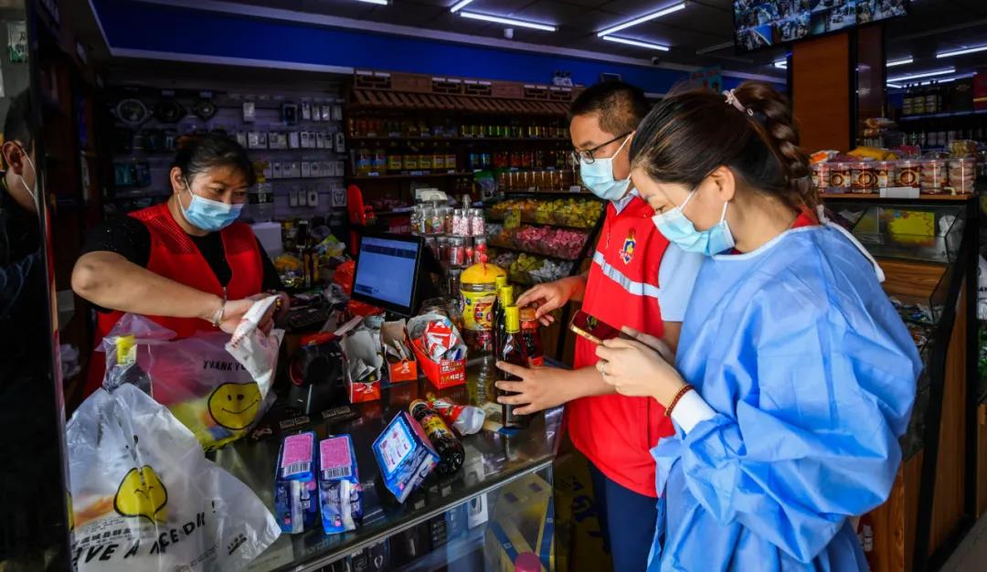 志愿者在禄口大街上的岗山超市帮居民采购生活物资。南报融媒体记者 董家训 摄