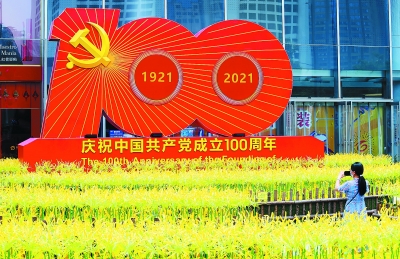 新街口的庆祝中国共产党成立100周年组合雕塑，引得市民驻足。 